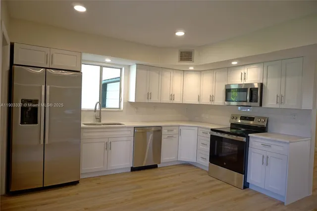 a kitchen with a refrigerator and a sink