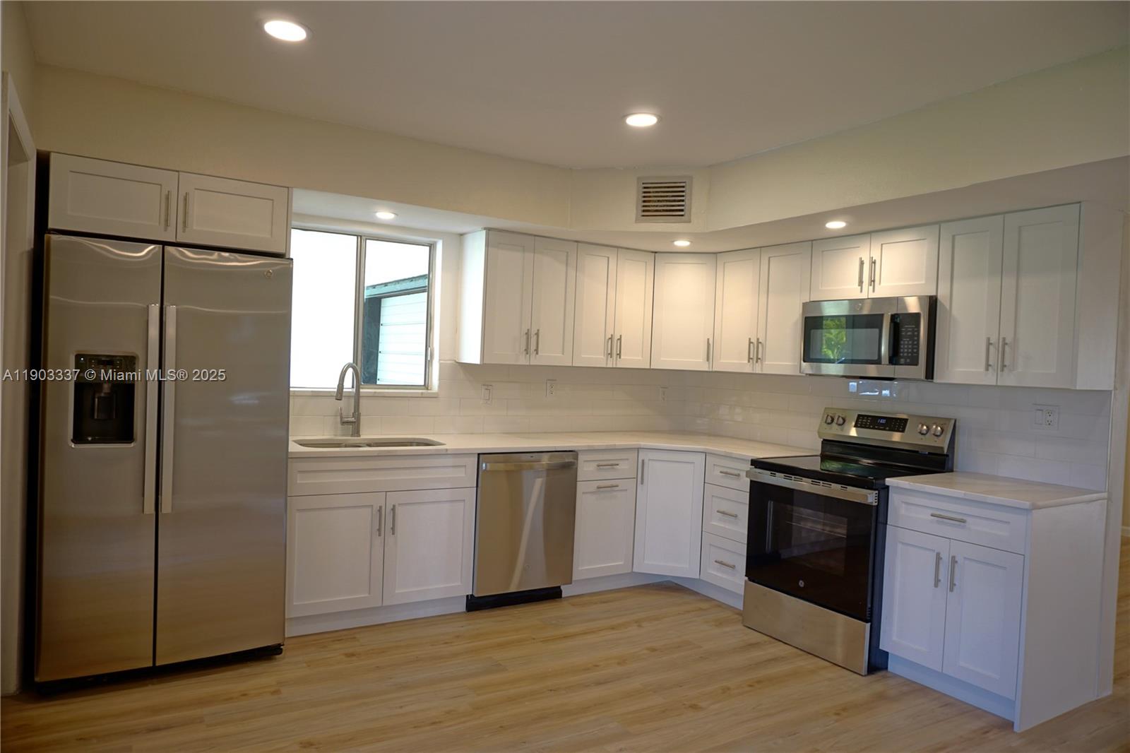 971 Fulton Lane Northeast Palm Bay, FL 32905 - Photo 2 of 29 a kitchen with a refrigerator and a sink