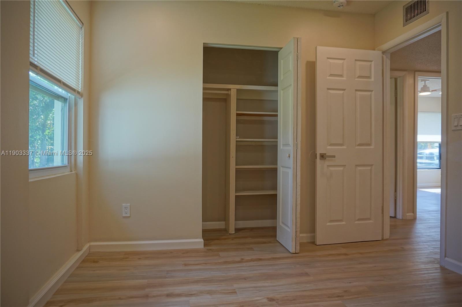 971 Fulton Lane Northeast Palm Bay, FL 32905 - Photo 24 of 29 an empty room with wooden floor closet and windows