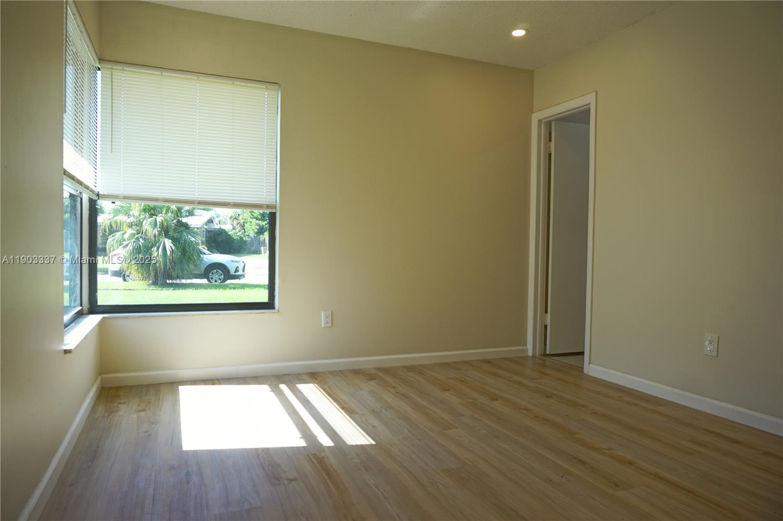 971 Fulton Lane Northeast Palm Bay, FL 32905 - Photo 26 of 29 an empty room with wooden floor and windows