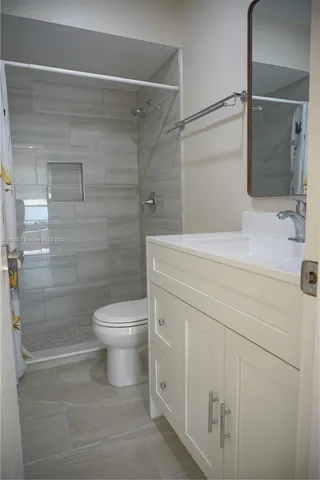 a bathroom with a shower toilet and sink