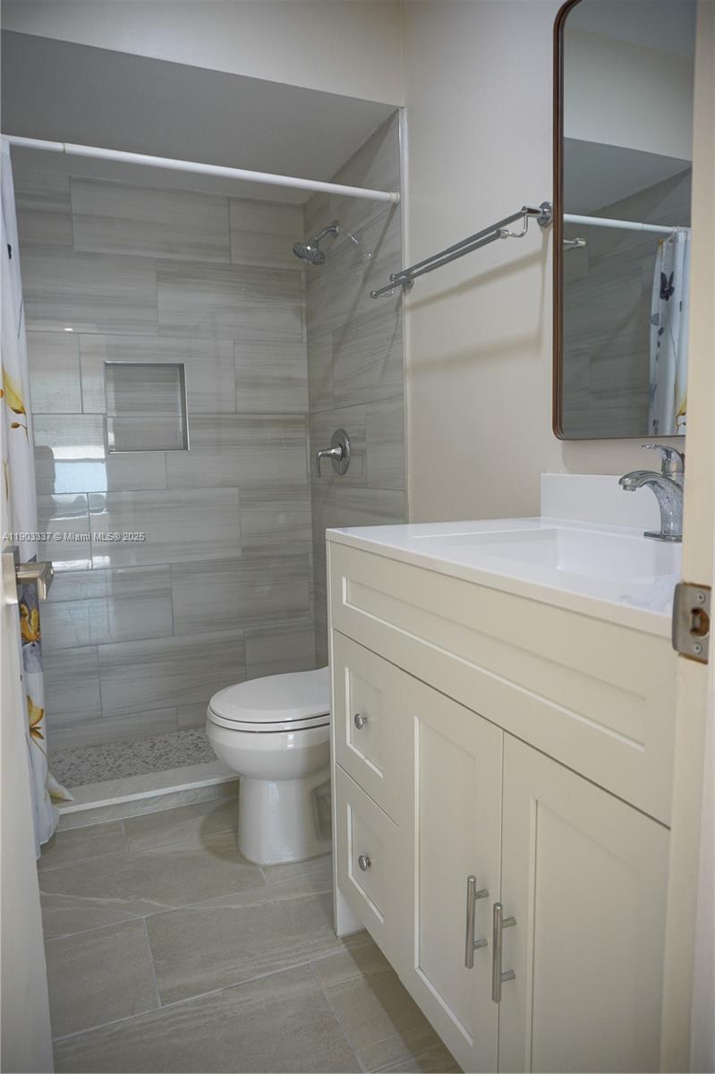 971 Fulton Lane Northeast Palm Bay, FL 32905 - Photo 4 of 29 a bathroom with a shower toilet and sink