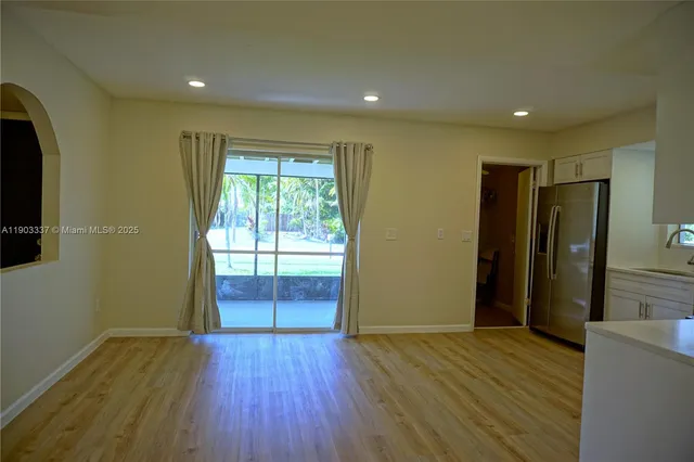 a view of hallway with a window and wooden floor