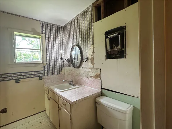 a bathroom with a toilet sink and mirror