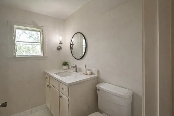 a bathroom with a toilet sink and mirror