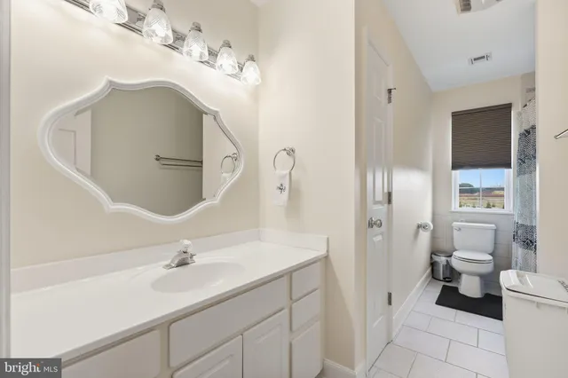 a bathroom with a sink a toilet and a mirror