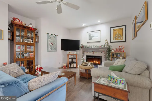 a living room with furniture a flat screen tv and a fireplace
