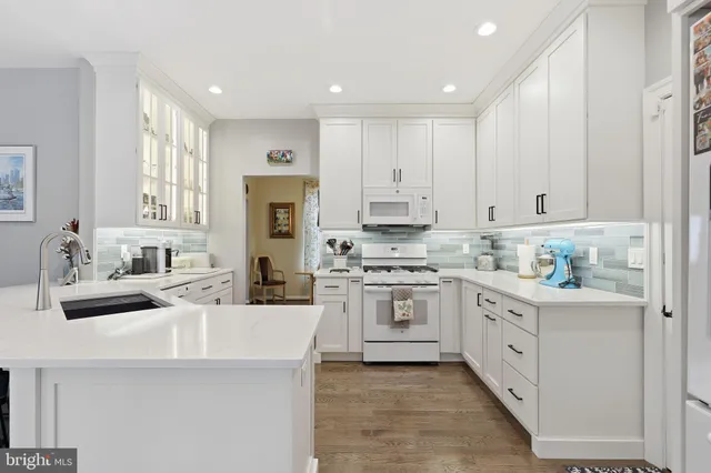 a kitchen with white cabinets and appliances