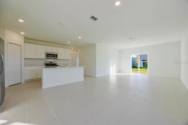 a view of kitchen with stainless steel appliances a refrigerator and a stove top oven