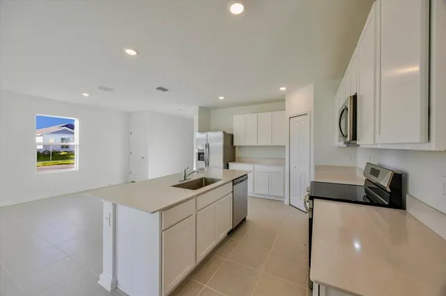a kitchen with stainless steel appliances a sink stove and cabinets