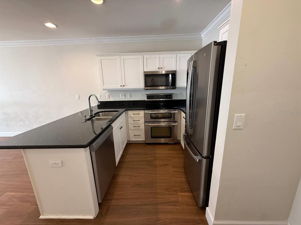 2513 West Kansas Avenue, Unit B Tampa, FL 33629 - Photo 5 of 27 a kitchen with stainless steel appliances a refrigerator a sink and white cabinets