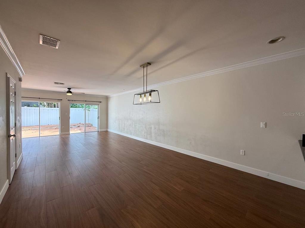 2513 West Kansas Avenue, Unit B Tampa, FL 33629 - Photo 9 of 27 an empty room with wooden floor and windows