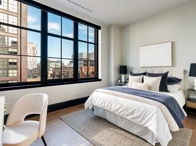 a bedroom with a bed and a large window