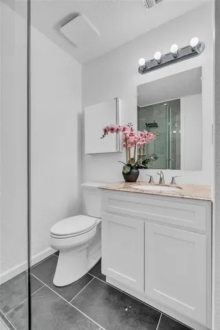 a bathroom with a sink vanity mirror and toilet