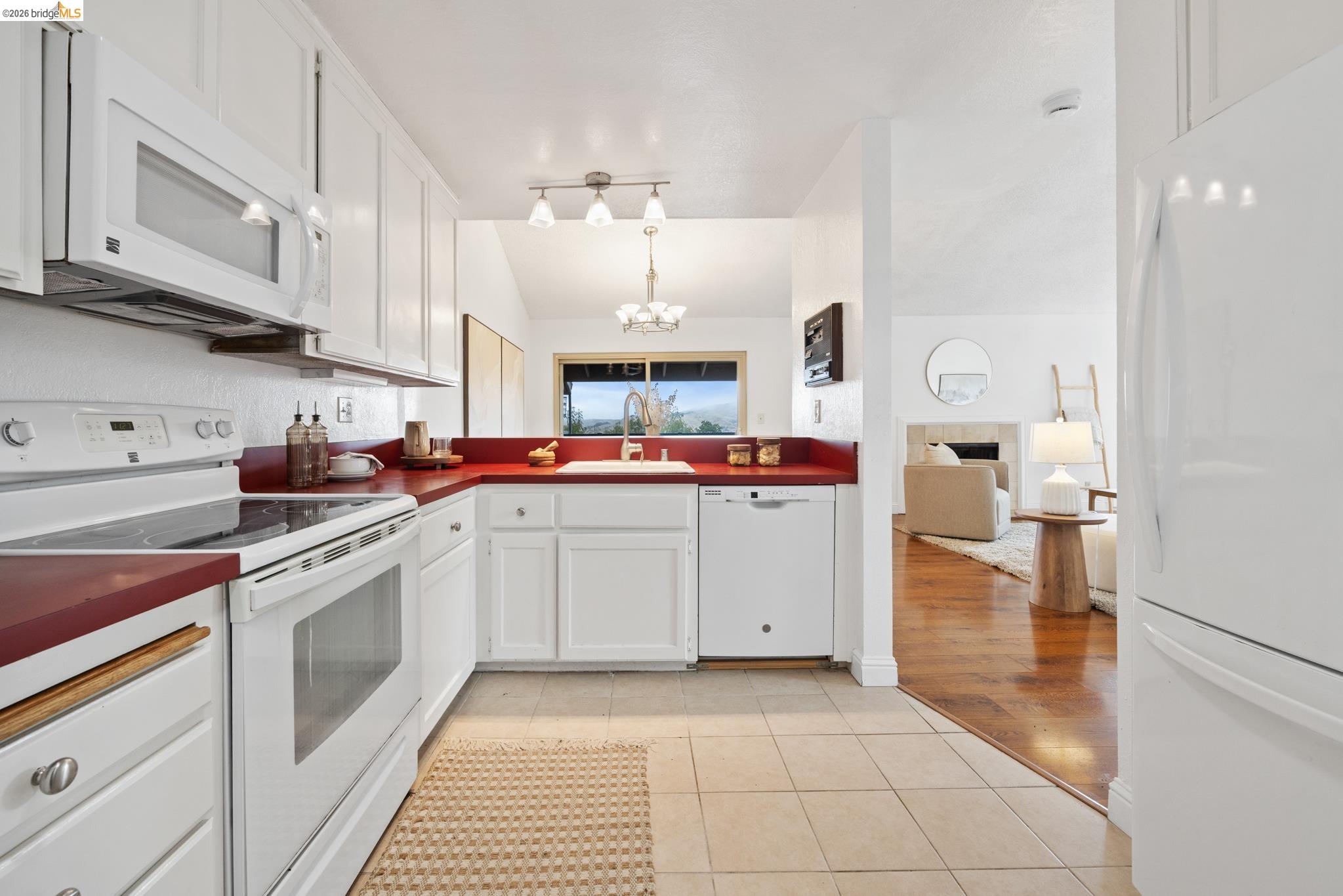 201 Vista Heights Road El Cerrito, CA 94530 - Photo 8 of 32 White kitchen cabinetry featuring red countertops, integrated dishwasher, and a white electric range with an overhead microwave