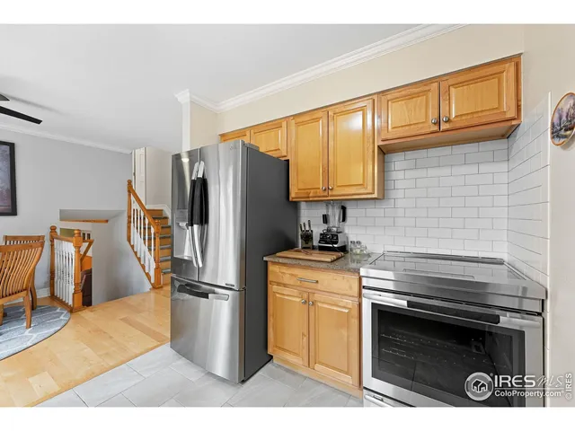 a kitchen with granite countertop a stove sink and refrigerator