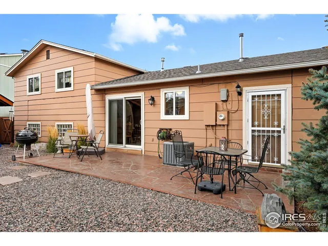 a backyard of a house with glass top table and chairs