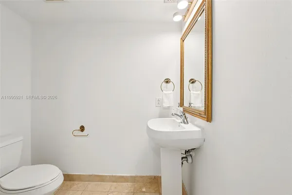 a bathroom with a sink toilet and a mirror