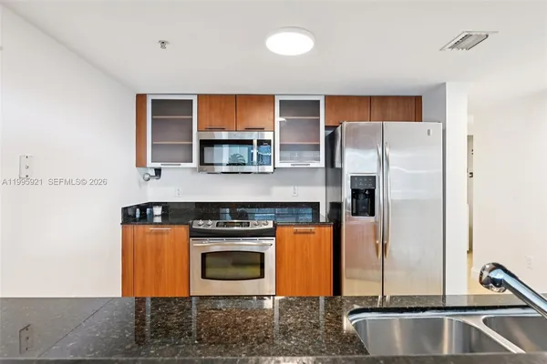 a kitchen with stainless steel appliances granite countertop a stove a refrigerator and a sink