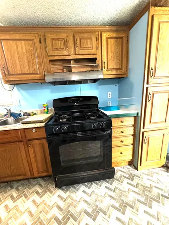 a kitchen with granite countertop a stove and a sink