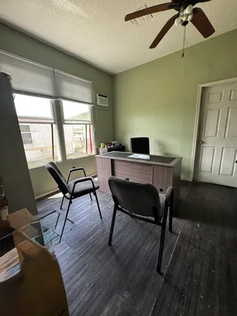 a view of a workspace with furniture and a window