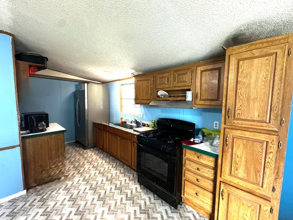a kitchen with granite countertop stainless steel appliances and wooden cabinets