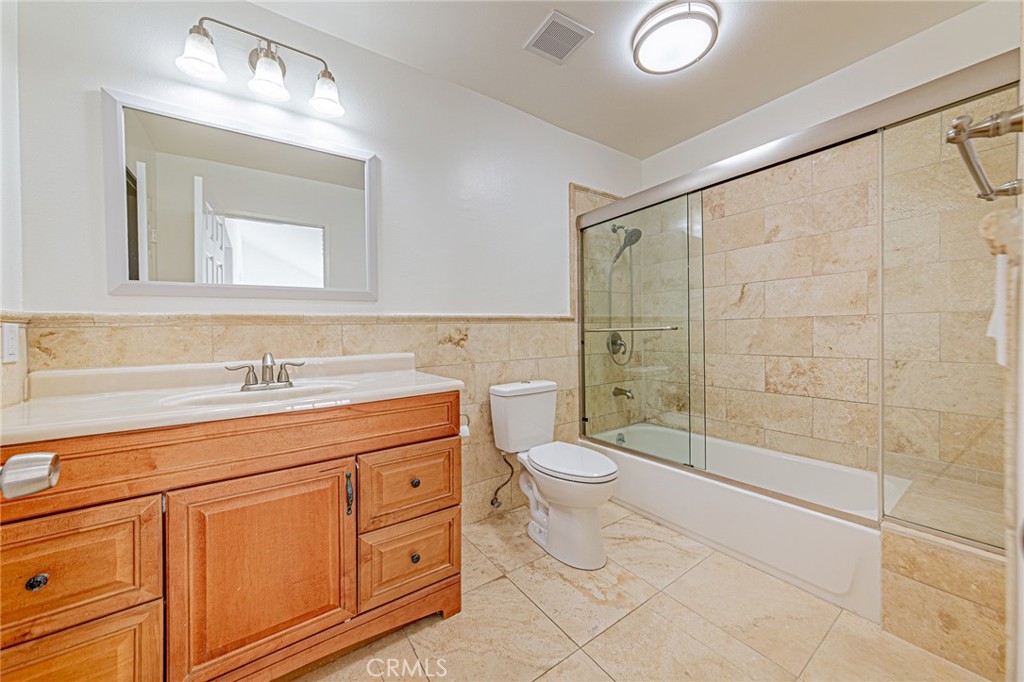 25533 Longfellow Place Stevenson Ranch, CA 91381 - Photo 31 of 47 a bathroom with a granite countertop sink a toilet and a shower