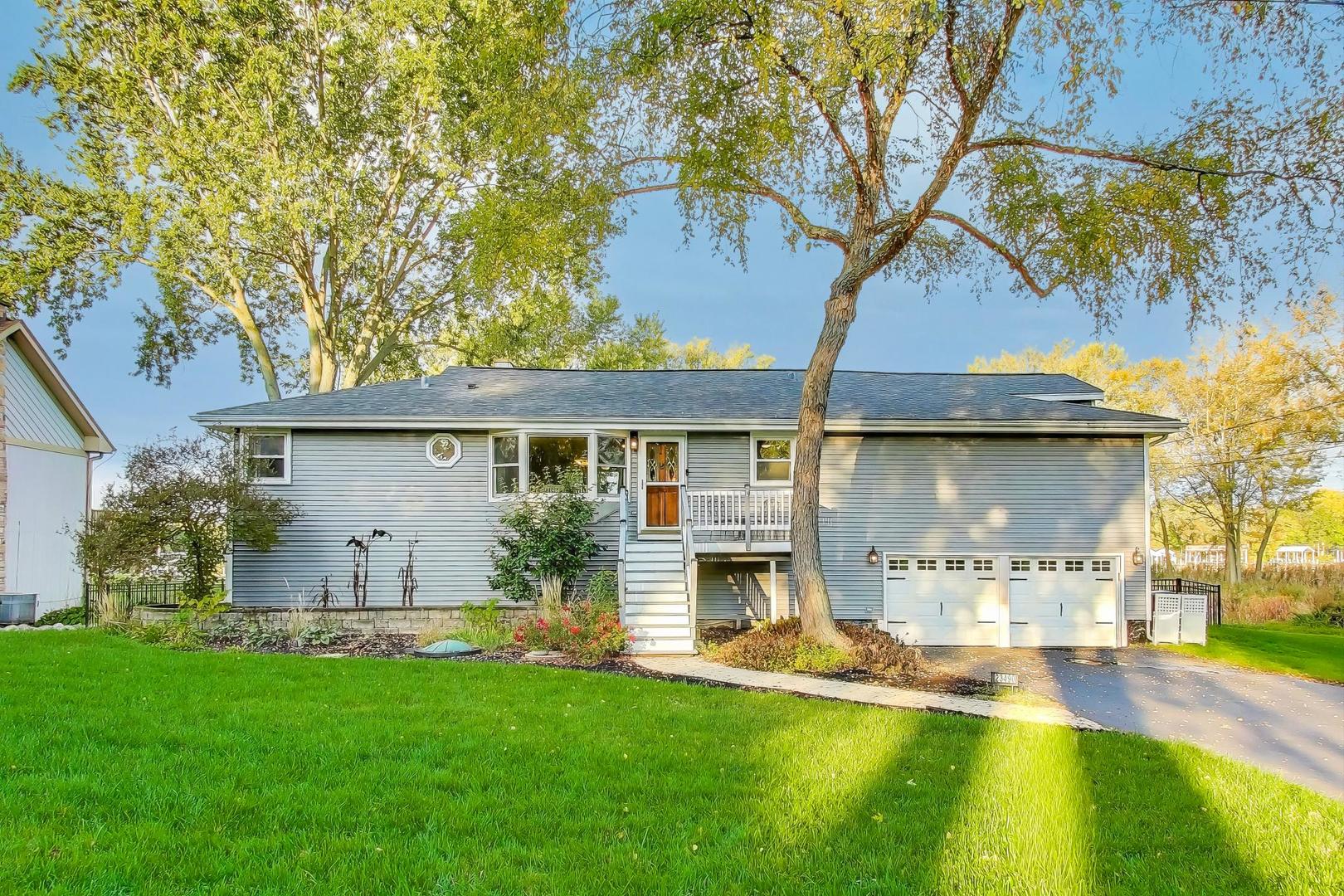 a view of a house with a yard patio and a tree