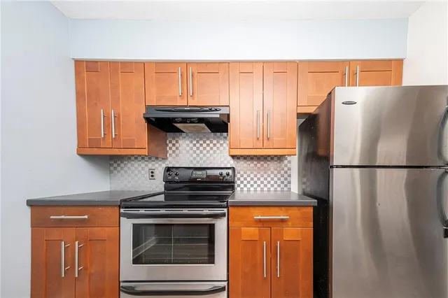 a kitchen with stainless steel appliances granite countertop a refrigerator stove a sink and dishwasher