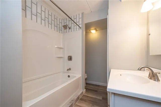 a bathroom with a tub a sink and mirror