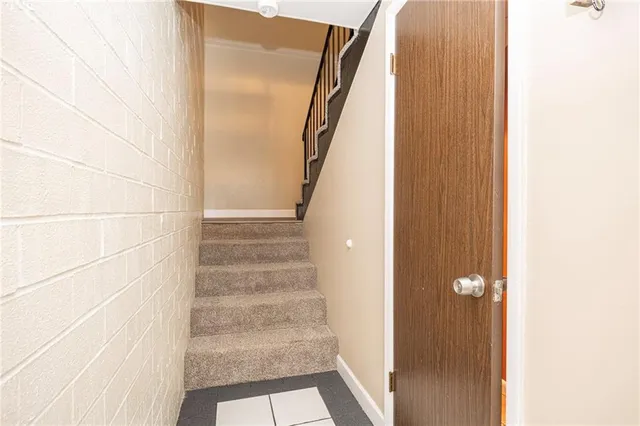 a view of staircase with white walls and white door