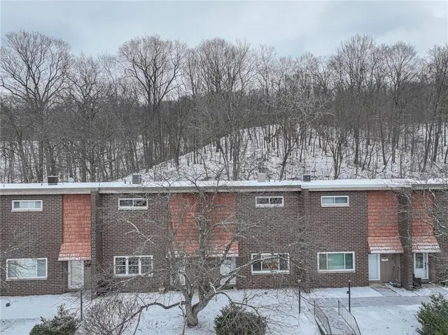a aerial view of a house with a yard and large tree