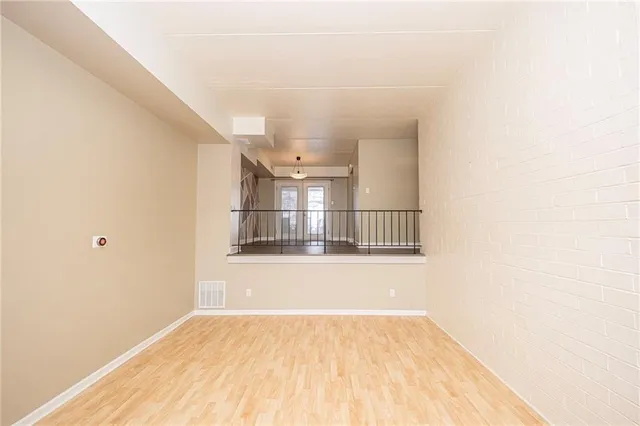 a view of empty room with wooden floor