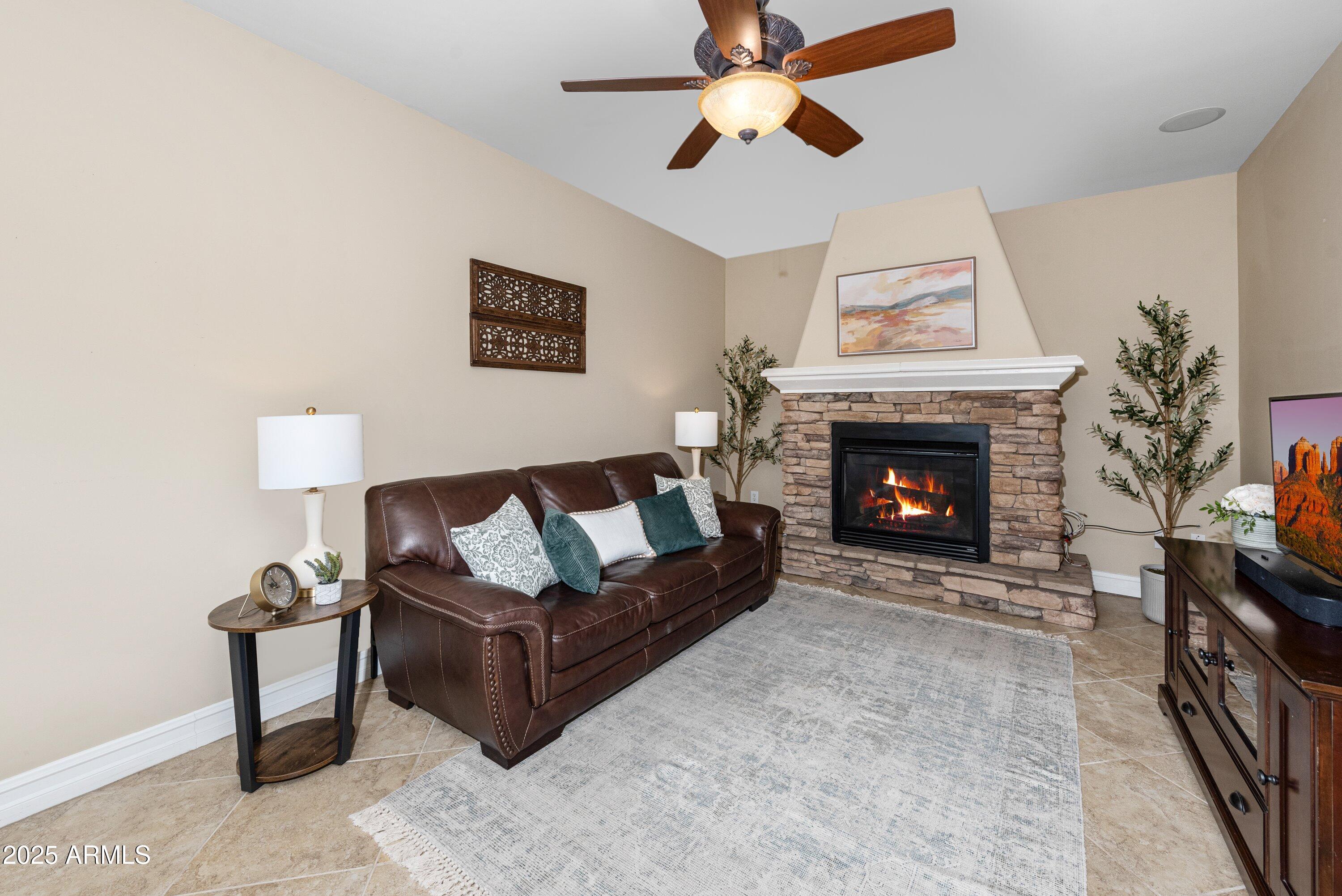 964 South Henry Lane Gilbert, AZ 85296 - Photo 5 of 48 a living room with furniture a flat screen tv and a fireplace