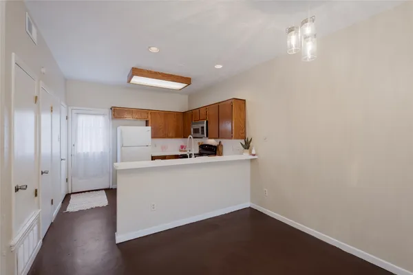 a kitchen with cabinets and wooden floor