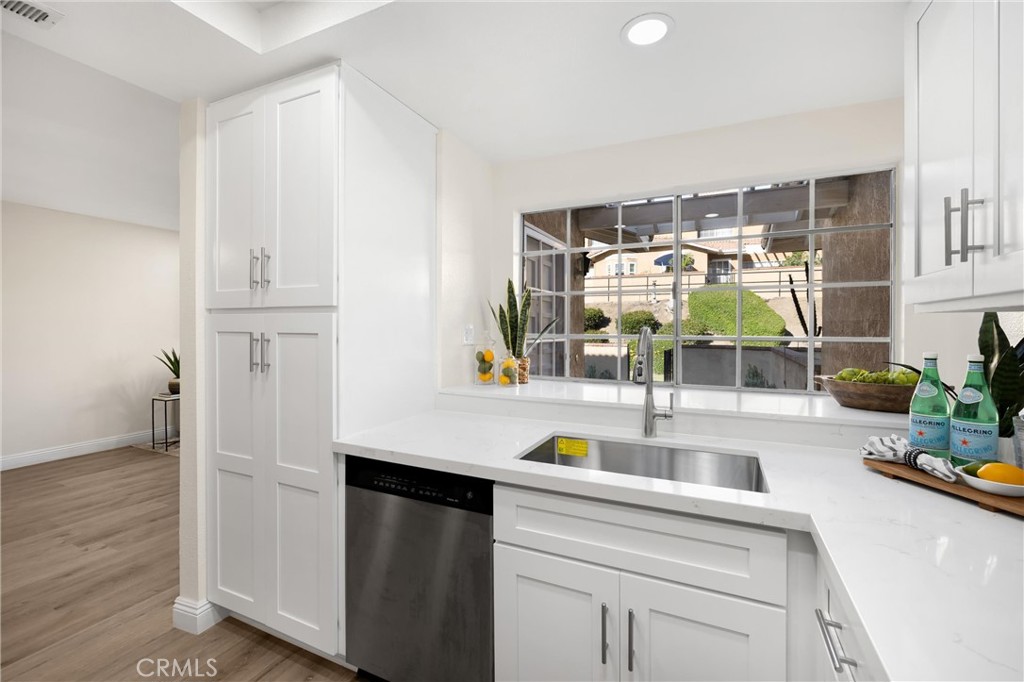 7268 Hermosa Avenue Rancho Cucamonga, CA 91701 - Photo 11 of 50 a kitchen with stainless steel appliances white cabinets and wooden floor