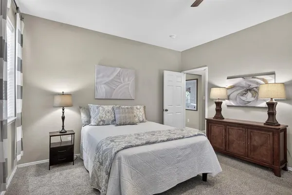 a bedroom with a large bed and a chandelier