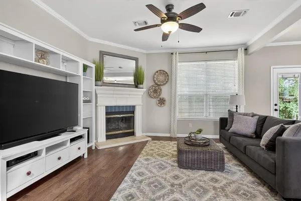 a living room with furniture a fireplace and a flat screen tv