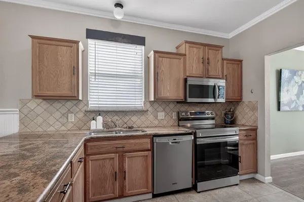 a kitchen with stainless steel appliances a stove microwave and sink