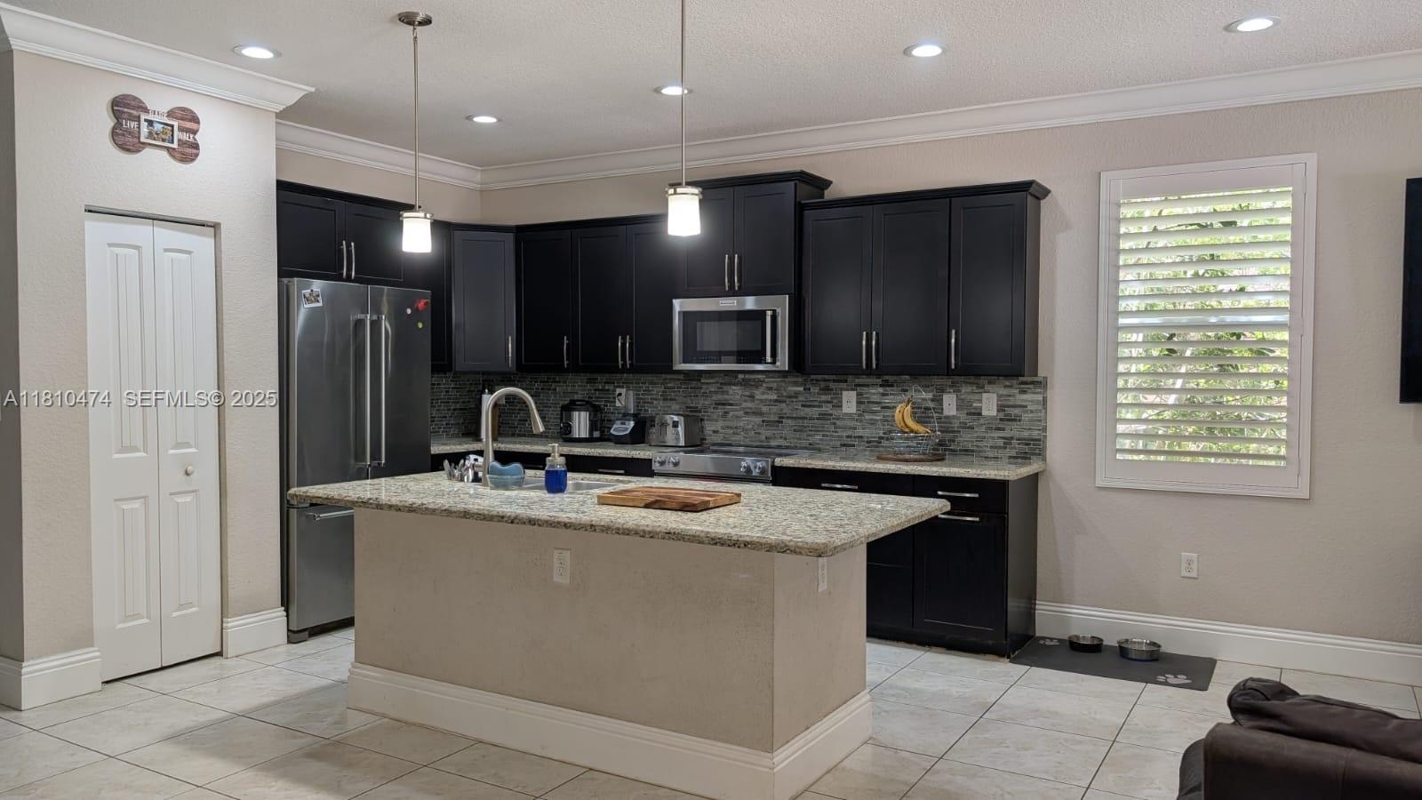 2230 Northwest 17th Avenue Homestead, FL 33030 - Photo 3 of 31 a kitchen with kitchen island stainless steel appliances a sink stove and refrigerator