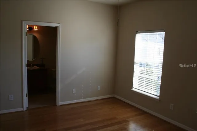 an empty room with wooden floor and a window
