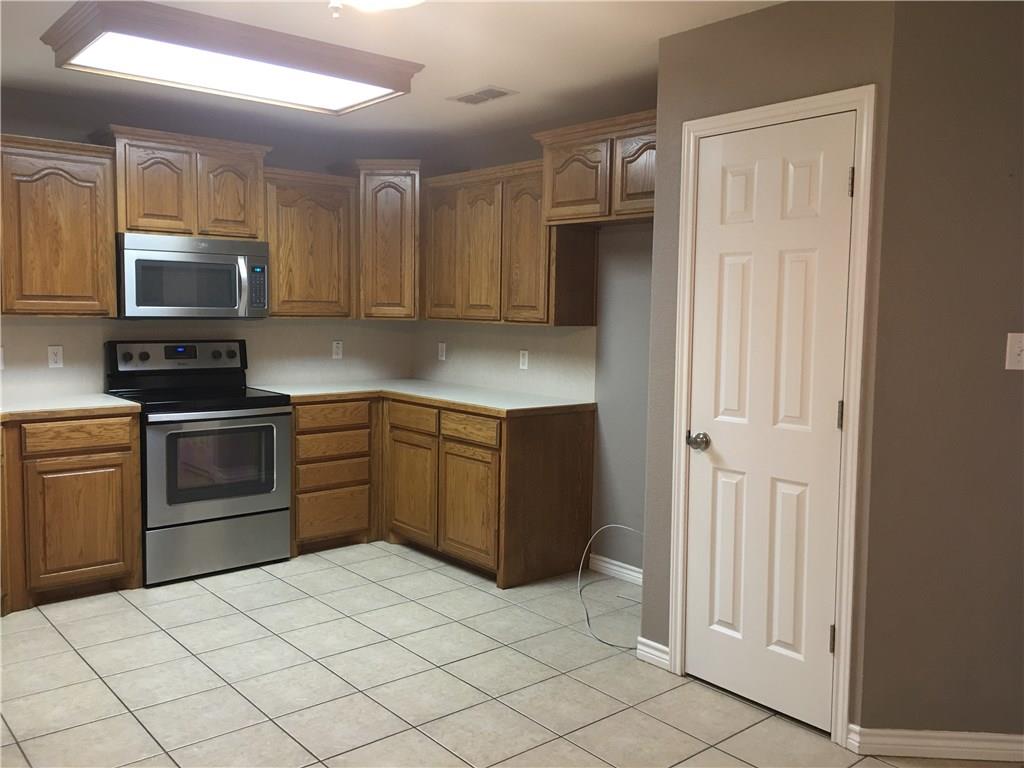 2218 Old Ironsides Road Abilene, TX 79601 - Photo 7 of 26 a kitchen with stainless steel appliances granite countertop a refrigerator and a stove top oven
