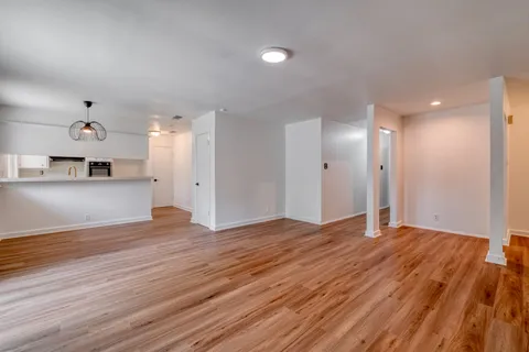 a view of empty room with wooden floor