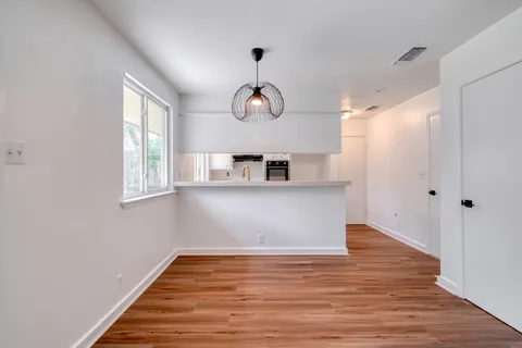 a view of a room with wooden floor and windows