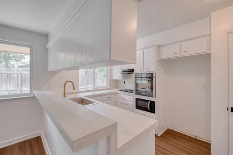 a kitchen with stainless steel appliances granite countertop a sink a stove and a refrigerator