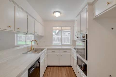 a kitchen with a sink stove and cabinets