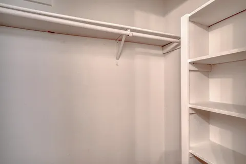 a view of walk in closet with empty racks