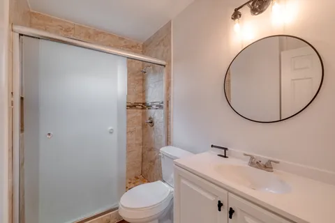 a bathroom with a sink a toilet and a mirror