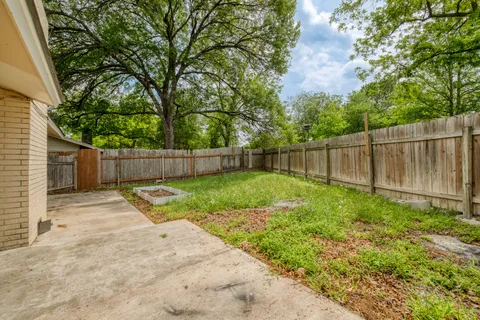 a view of backyard with wooden fence