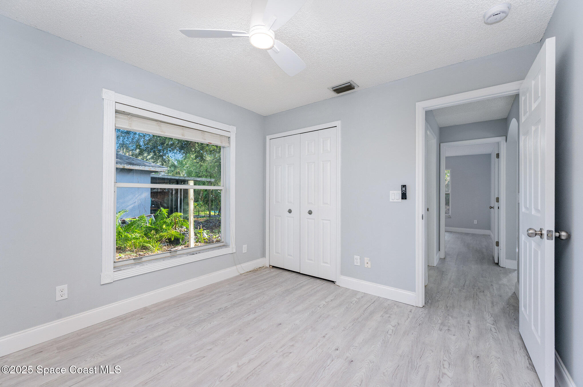 4285 Glover Street Cocoa, FL 32927 - Photo 19 of 25 an empty room with wooden floor and windows